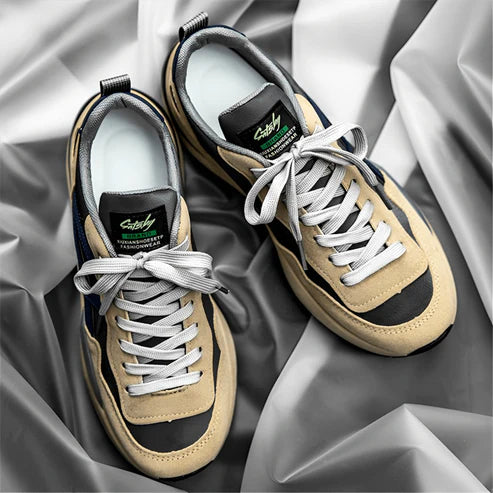 O Tênis Masculino Romenzi RZ383 está disponível em bege e cinza, com acabamento em couro e camurça, palmilha em látex e sola antiderrapante segura.