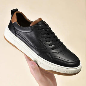 Tênis masculino Romenzi RZ413 em couro preto e branco, solado de borracha durável e design minimalista para looks casuais com sofisticação.